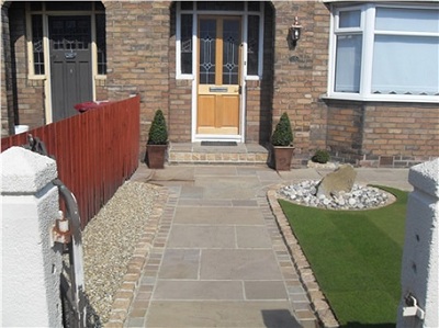 A finished garden with paving, a lawn edge and timber fencing.
